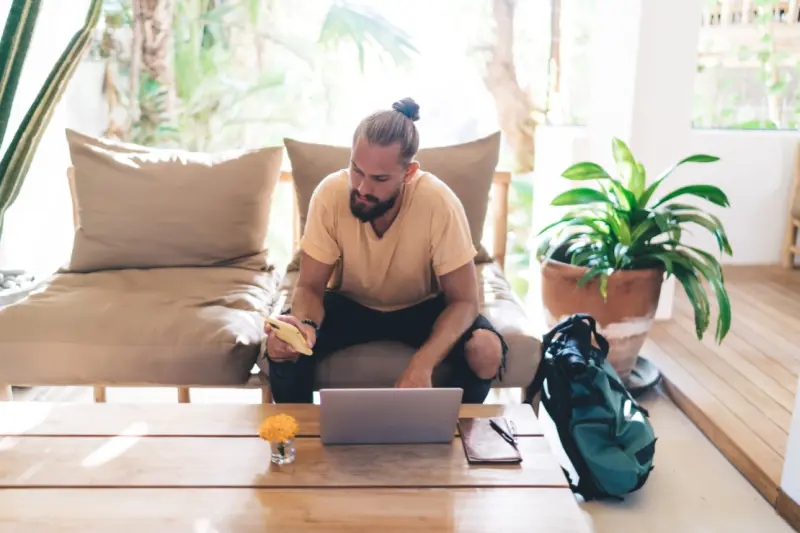 man sitting with smartphone and laptop at table